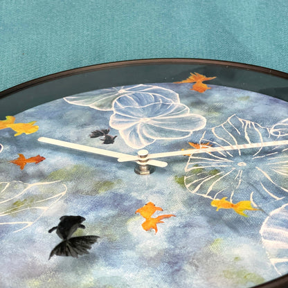 Blue plastic NeXtime Clocks wall clock, 30cm silent design with pond-themed face, ideal for modern home decor.