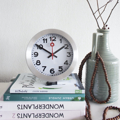NeXtime Clocks aluminum wall or table clock with station number design, featuring a sleek modern style and clear time display.
