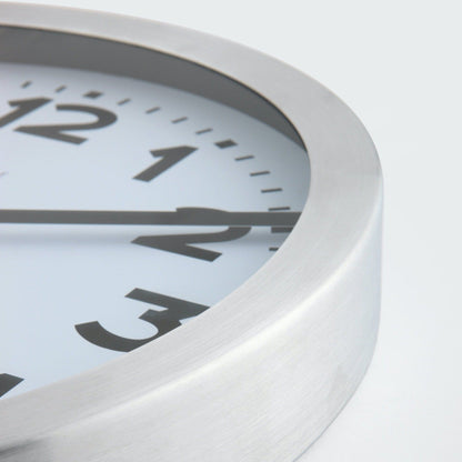 NeXtime Clocks aluminum wall or table clock with station number design, featuring a sleek modern look and clear time display.
