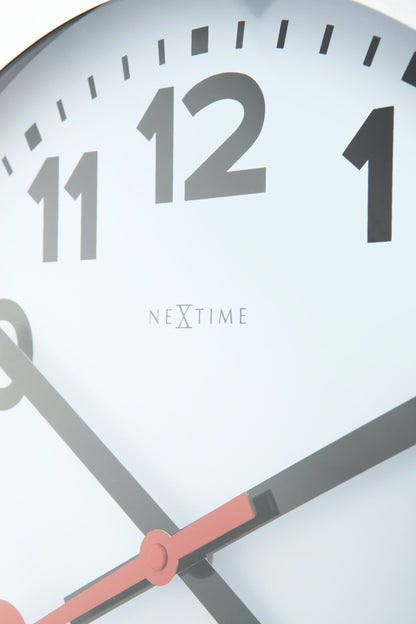 NeXtime Clocks aluminum wall or table clock with station number design, featuring a sleek modern appearance and clear time display.