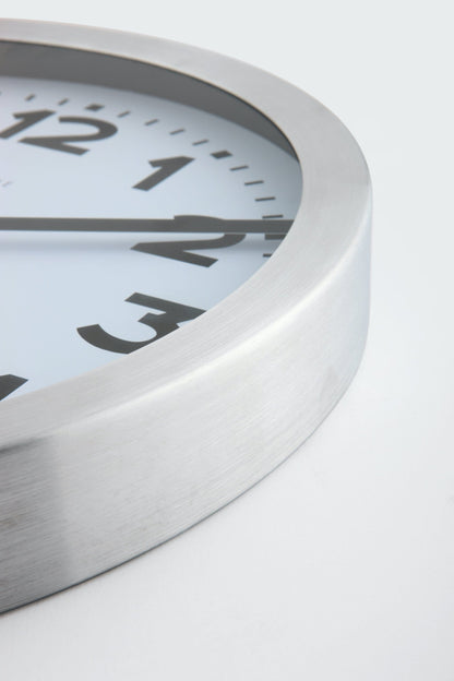 NeXtime Clocks aluminum wall or table clock featuring station number design with clear clock face and modern style.