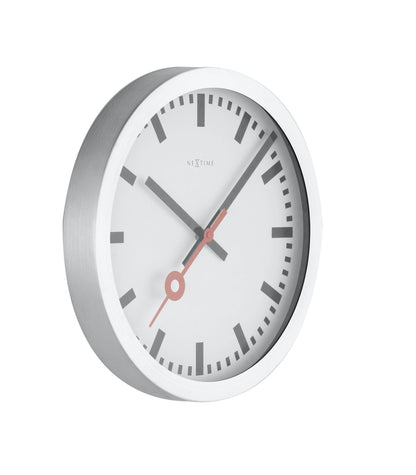 NeXtime Clocks Station Stripe aluminum wall or table clock showing a sleek, modern design with a striped pattern on the right side.