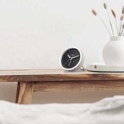 Small NeXtime metal table alarm clock with light function, silent operation, 9x9x7.5cm, designed for bedside or desk use.