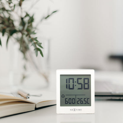 NeXtime digital alarm clock with LED display, compact size, black plastic housing, and "Wake Up" label on the front.