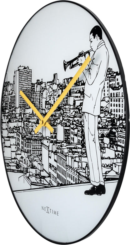 NeXtime Clocks wall clock with a 40 cm glass and metal design featuring a trumpet city scene on the right side.