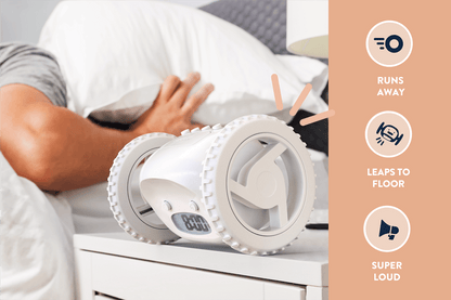 White NeXtime Clocky alarm clock with wheels, featuring a modern design and digital display, shown in a lifestyle setting.