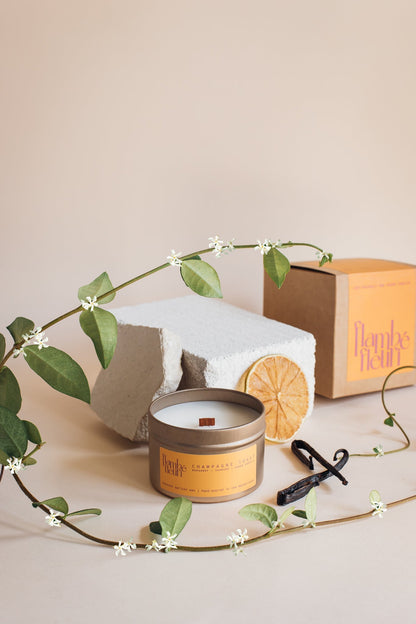 Flambé Fleuri Champagne Toast candle in a decorative tin with a champagne glass design, ideal for celebratory home decor.